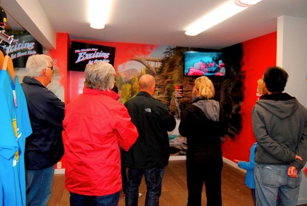 Guests view DVD footage at Shotover Jet base building.